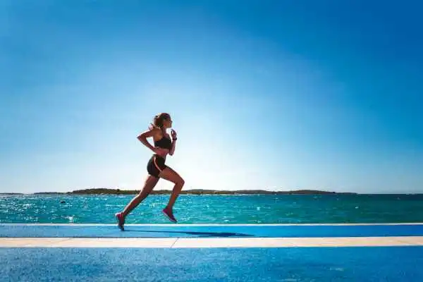 Woman running showing strong leg muscle Merthyr Tydfil